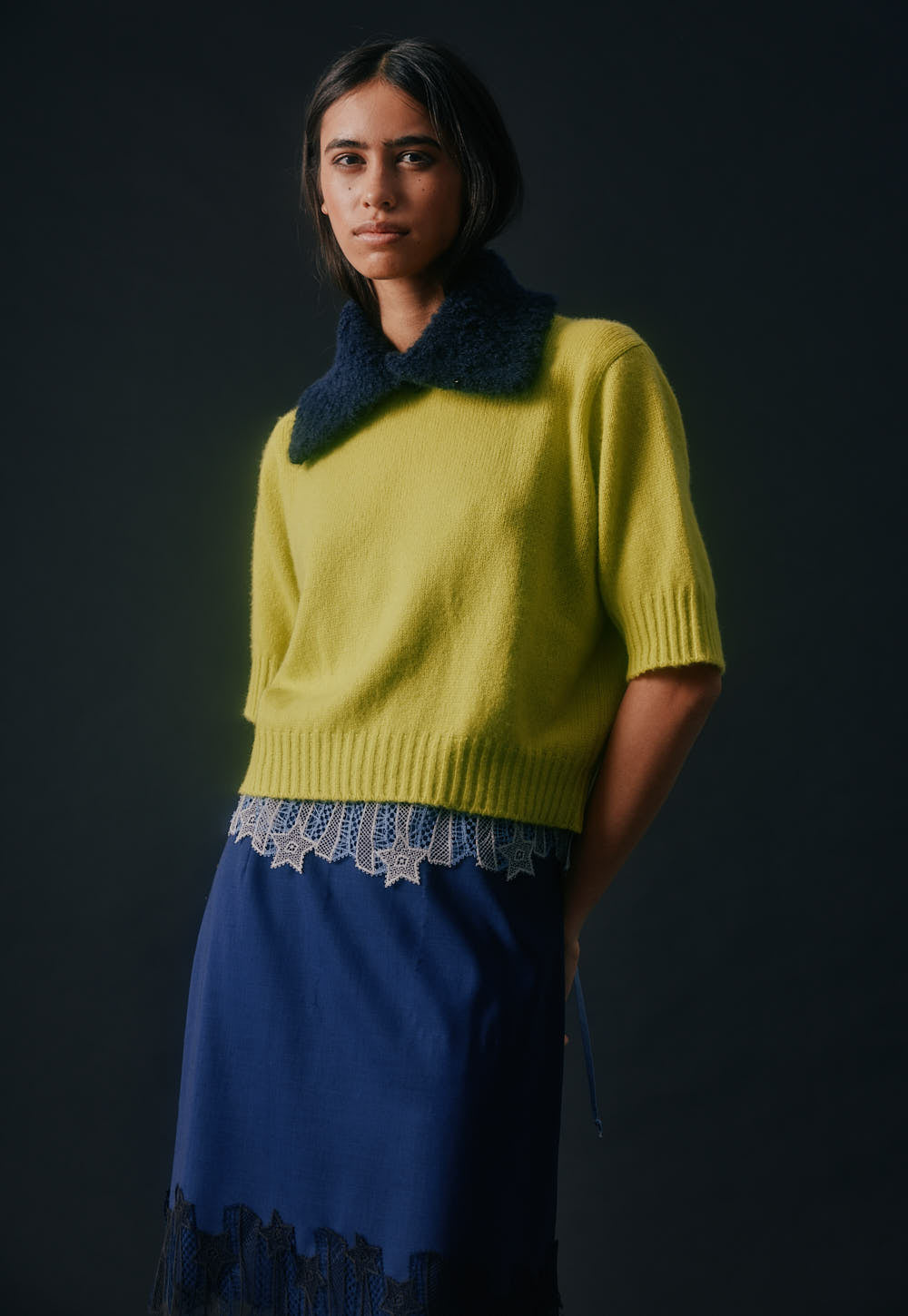 Model wearing Kiwi Niki Sweater Nuage with lace and navy skirt