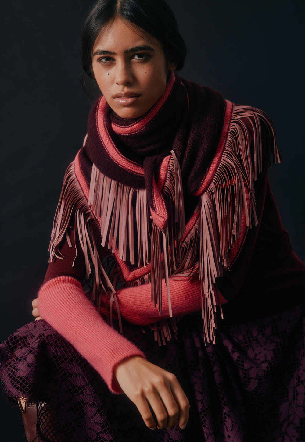 Fine turtleneck sweater layered with fringed cashmere triangle scarf, close-up detail